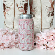 pink floral and cowgirl boot pattern can sleeve on silver skinny can with boots and flowers in the background